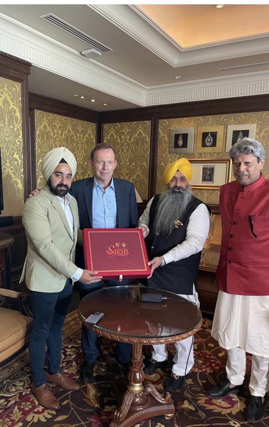 Raj Pahwa presenting a book with former Prime Minister Tony Abbott and community leaders