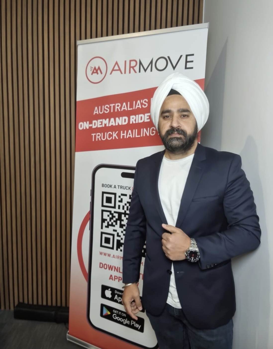 Raj Pahwa in front of an Airmove banner